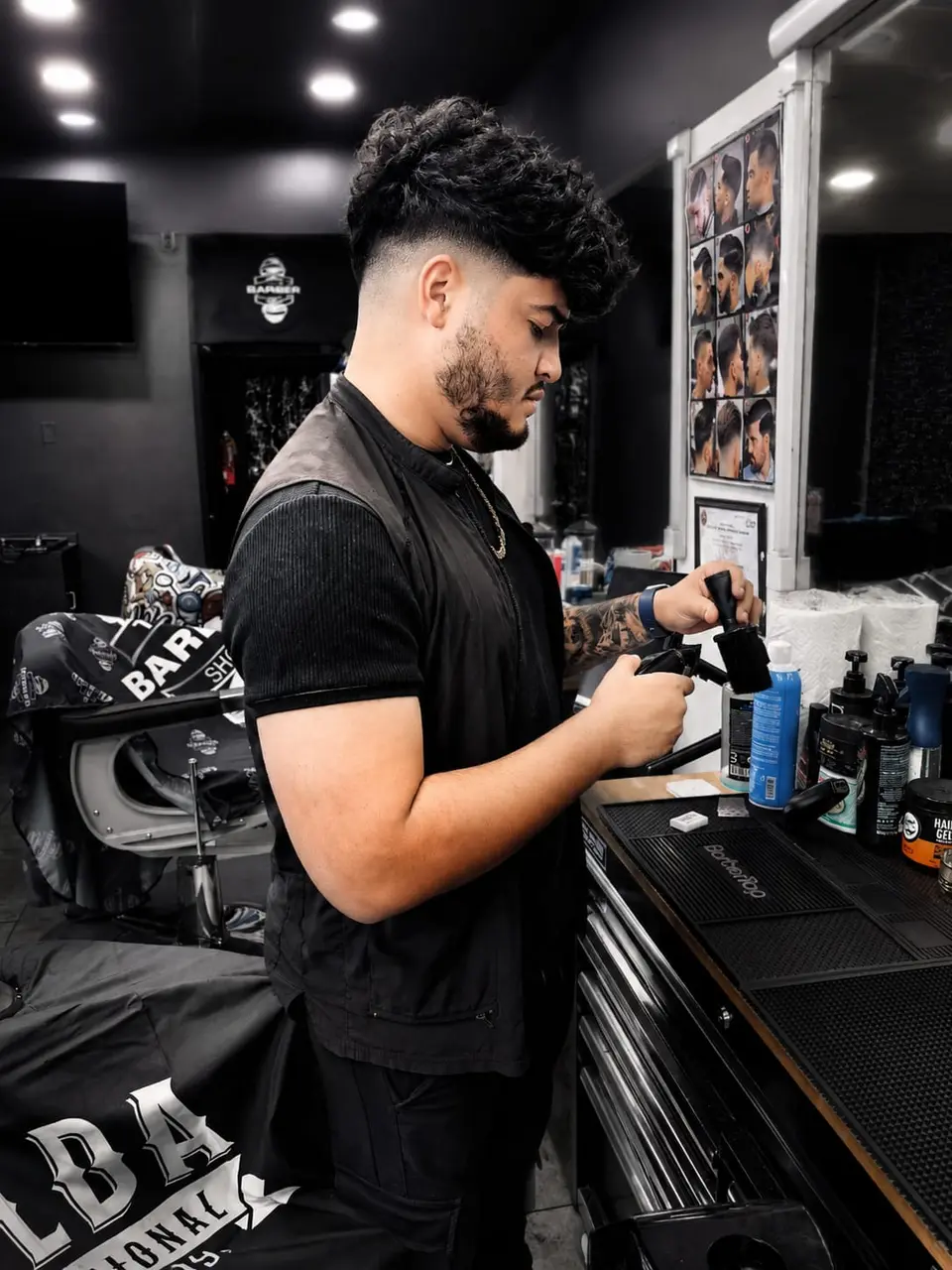 Barbero preparando sus herramientas frente al espejo de la barbería